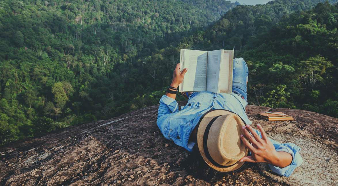 Man reading book on mountain